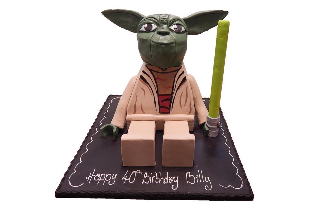 A cake featuring a LEGO Yoda Minifigure sitting